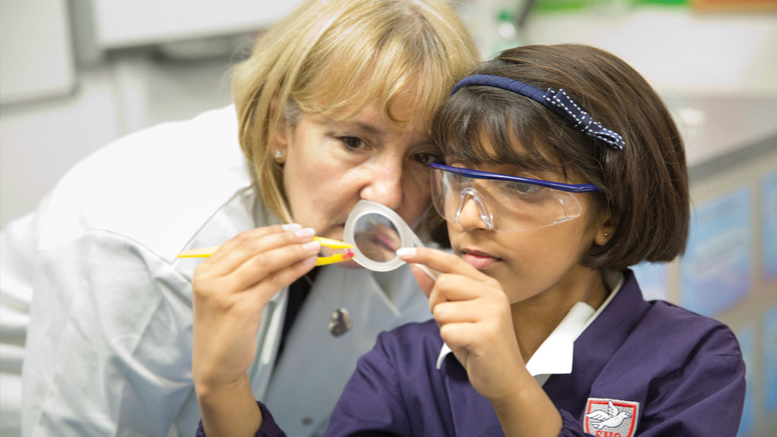 Girl and Teacher in a Science Lesson